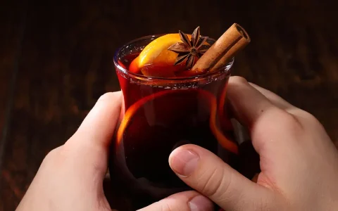 Hände halten ein Glas mit Glühwein