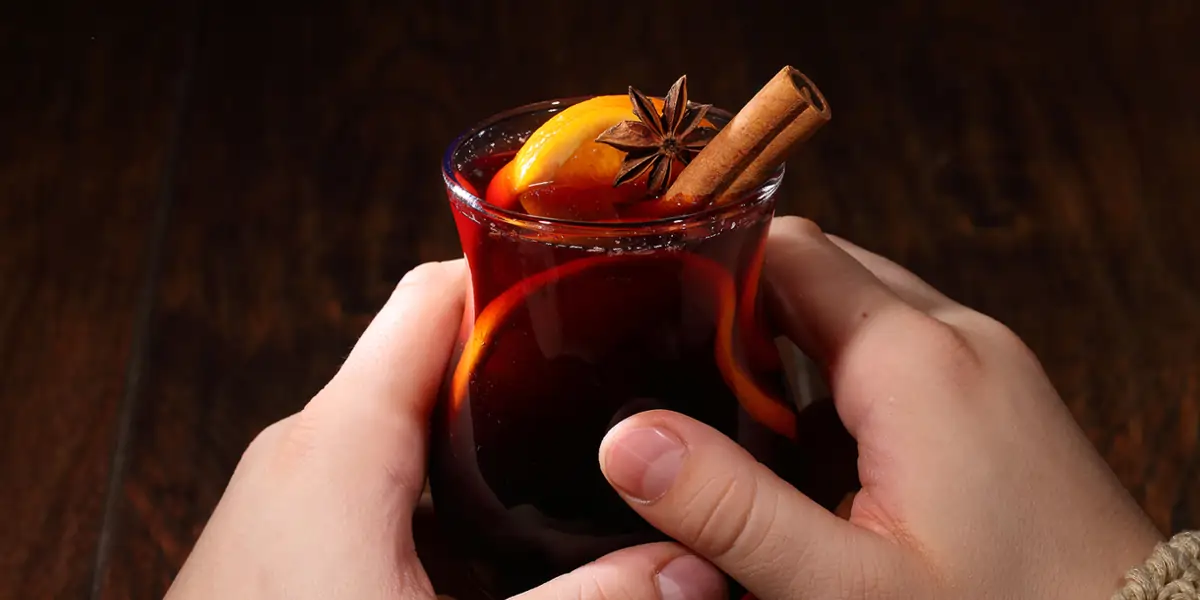 Hände halten ein Glas mit Glühwein